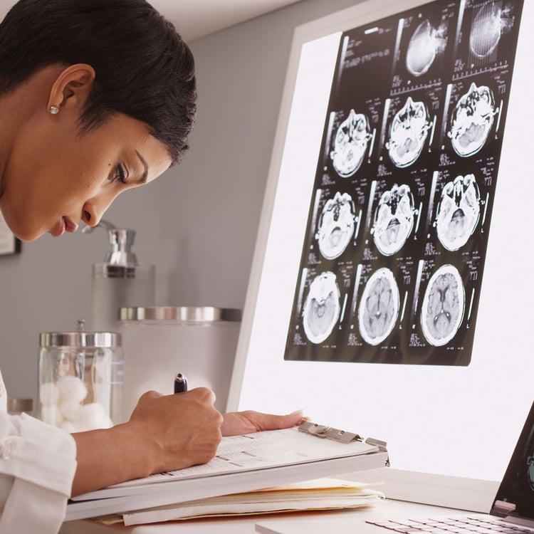 African medical woman reading x-ray results of a brain